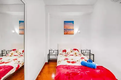 a bedroom with two beds and a mirror at Relax Les Palmeres in Sueca