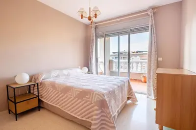 a bedroom with a bed and a large window at Global Vacacional, apartamento cerca del mar en Canet in Canet de Berenguer
