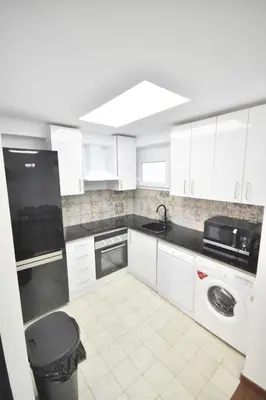 a white kitchen with a sink and a dishwasher at Gran piso en barrio historico del centro in Valencia