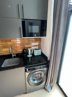 a kitchen with a washing machine and a microwave at Vip Apartments Valencia in Valencia