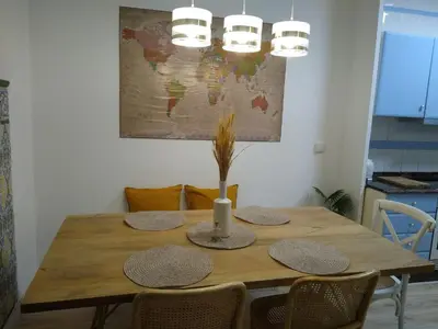 a dining room table with chairs and a wooden table with lights at Casa con encanto y terraza junto a la playa in Valencia