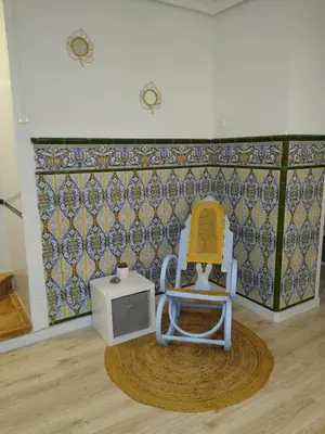 a chair and a tv in a room at Casa con encanto y terraza junto a la playa in Valencia