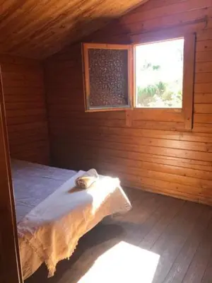 a bed in a wooden room with a window at Retiro Siete Aguas in Siete Aguas