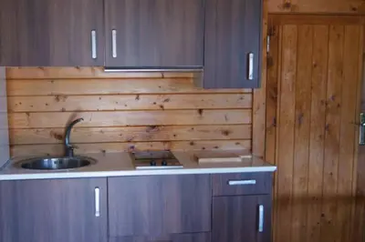 a kitchen with a sink and a wooden wall at Retiro Siete Aguas in Siete Aguas