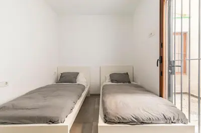 two beds in a white room with a window at Vivienda junto a Ruzafa - 12 PAX y más in Valencia