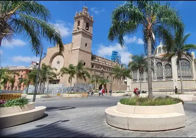 a large building with a clock tower and palm trees at Cozy LUXURY apartments*****. The city center in Valencia
