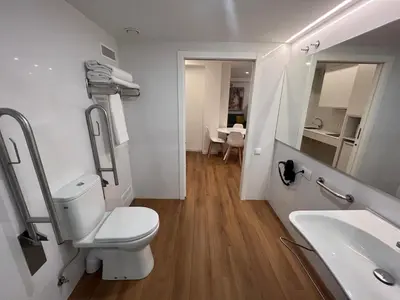 a white bathroom with a toilet and a sink at Old Town Flats Casa del Bisbe in Valencia