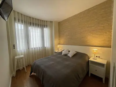 a bedroom with a bed and two tables with lamps at Luxury double Suite at heart of Ruzafa in Valencia