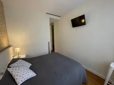 a bedroom with a bed and a television on the wall at Luxury double Suite at heart of Ruzafa in Valencia