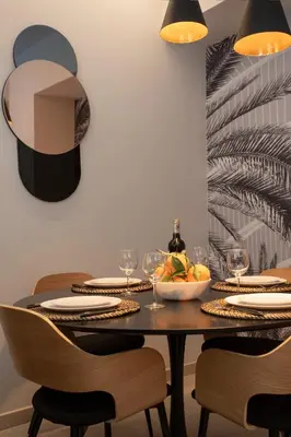 a dining room with a table with plates and glasses at Neobeds - Stylish modern 1BR Apt Near Old Town & Steps from Turia Park in Valencia