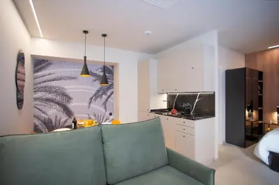 a living room with a green couch and a kitchen at Neobeds - Stylish modern 1BR Apt Near Old Town & Steps from Turia Park in Valencia