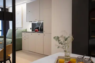 a kitchen with white cabinets and a table with oranges at Neobeds - Stylish modern 1BR Apt Near Old Town & Steps from Turia Park in Valencia