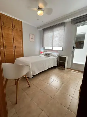 a bedroom with a bed and a chair and a window at El Recreo, private Pool & Bbq in Godelleta