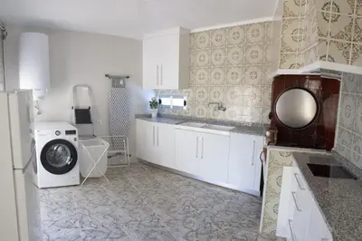 a kitchen with a washing machine and a washer at El Recreo, private Pool & Bbq in Godelleta