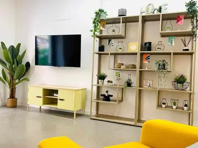 a living room with a tv and a yellow furniture at Tarongers, lovely flat in the center in Valencia