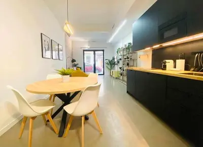 a kitchen with a wooden table and white chairs at Tarongers, lovely flat in the center in Valencia