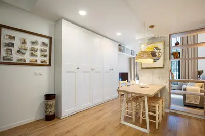 a kitchen with white cabinets and a wooden table at ApartUP Opera Loft Love in Valencia
