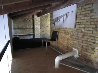 a room with a black chair and a wall with a screen at Young Penthouse in Valencia
