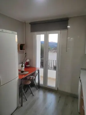a kitchen with a table and a door with a balcony at Apartamento rural Casa Calo in Losa del Obispo