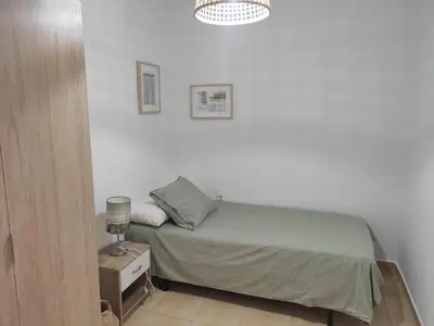 a small bedroom with a bed and a lamp at Apartamento rural Casa Calo in Losa del Obispo