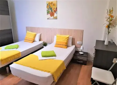 two beds in a room with yellow and white at Double cozy room. Ruzafa - perfect place to stay in Valencia
