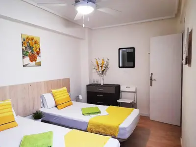 a bedroom with two beds with yellow and white sheets at Double cozy room. Ruzafa - perfect place to stay in Valencia
