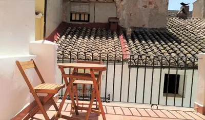 two chairs and a table on a balcony at Casa El Olmo de Navajas in Navajas