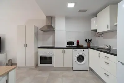 a kitchen with white cabinets and a washing machine at Magnifico apartamento cerca del centro con A.A. - CID 2 in Burriana