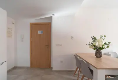 a dining room with a table and a vase of flowers at Magnifico apartamento cerca del centro con A.A. - CID 2 in Burriana