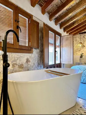 a bath tub in a room with a bedroom at ruralhome callemayor in Altura
