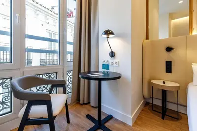 a room with a table and chair and a balcony at Petit Palace Plaza de la Reina in Valencia