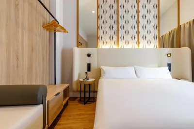 a bedroom with a white bed and a chair at Petit Palace Plaza de la Reina in Valencia