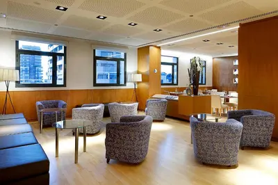 a waiting room with chairs and tables and windows at Eurostars Gran Valencia in Valencia