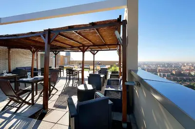 a balcony with tables and chairs on a building at Eurostars Gran Valencia in Valencia