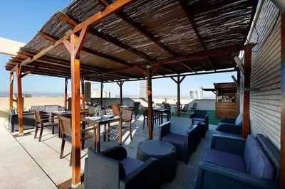 a patio with chairs and tables and a wooden pergola at Eurostars Gran Valencia in Valencia