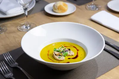 a white bowl of soup on a table at Eurostars Acteón in Valencia