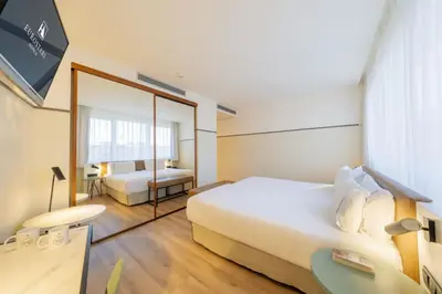 a hotel room with a bed and a mirror at Eurostars Acteón in Valencia