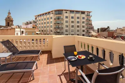 a balcony with a table and chairs on a roof at Catalonia Excelsior in Valencia