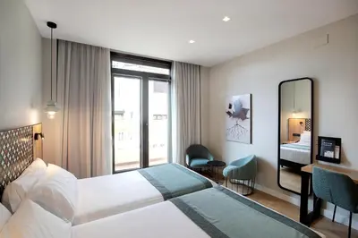 a hotel room with a bed and a mirror at Catalonia Excelsior in Valencia