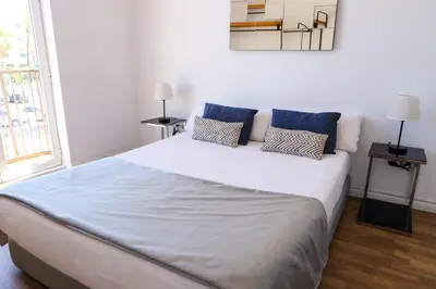 a bedroom with a large white bed with blue pillows at Valencia Luxury - Malvarrosa Beach in Valencia