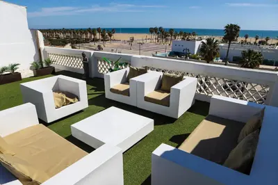 a balcony with white chairs and tables and the beach at Valencia Luxury - Malvarrosa Beach in Valencia