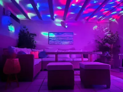 a room with purple and pink lights and a couch at Ático frente al mar, PataconaBlue, complejo vacacional in Valencia