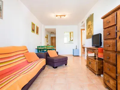 a bedroom with a bed and a tv and a couch at Apartment Las Dunas by Interhome in Moncófar