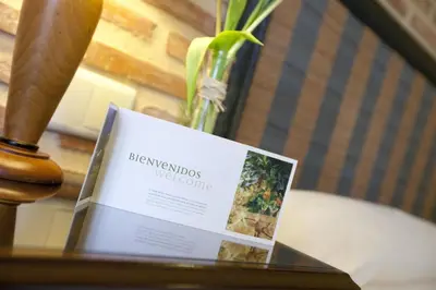 a book on a table with a vase of flowers at Ad Hoc Parque in Bétera