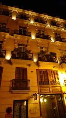 a lit up building with windows and balconies at night at Ad Hoc Monumental 1881 in Valencia