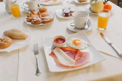 a table topped with plates of breakfast foods and orange juice at Ad Hoc Monumental 1881 in Valencia