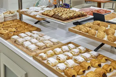 a bakery with many different types of pastries on display at NH Valencia Las Ciencias in Valencia