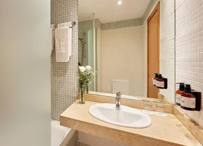 a bathroom with a sink and a mirror at NH Valencia Las Ciencias in Valencia