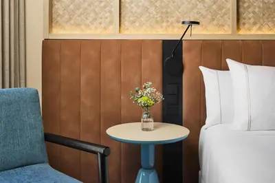 a hotel room with a bed and a table with flowers at NH Valencia Center in Valencia