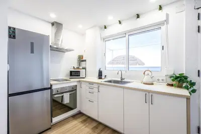 a kitchen with white cabinets and a large window at Lux Penthouse Mediterranean views Beach front in Puerto de Sagunto